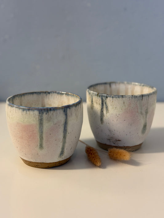 Handgemachte Becher glasiert in weiß mit blauen Tropfen