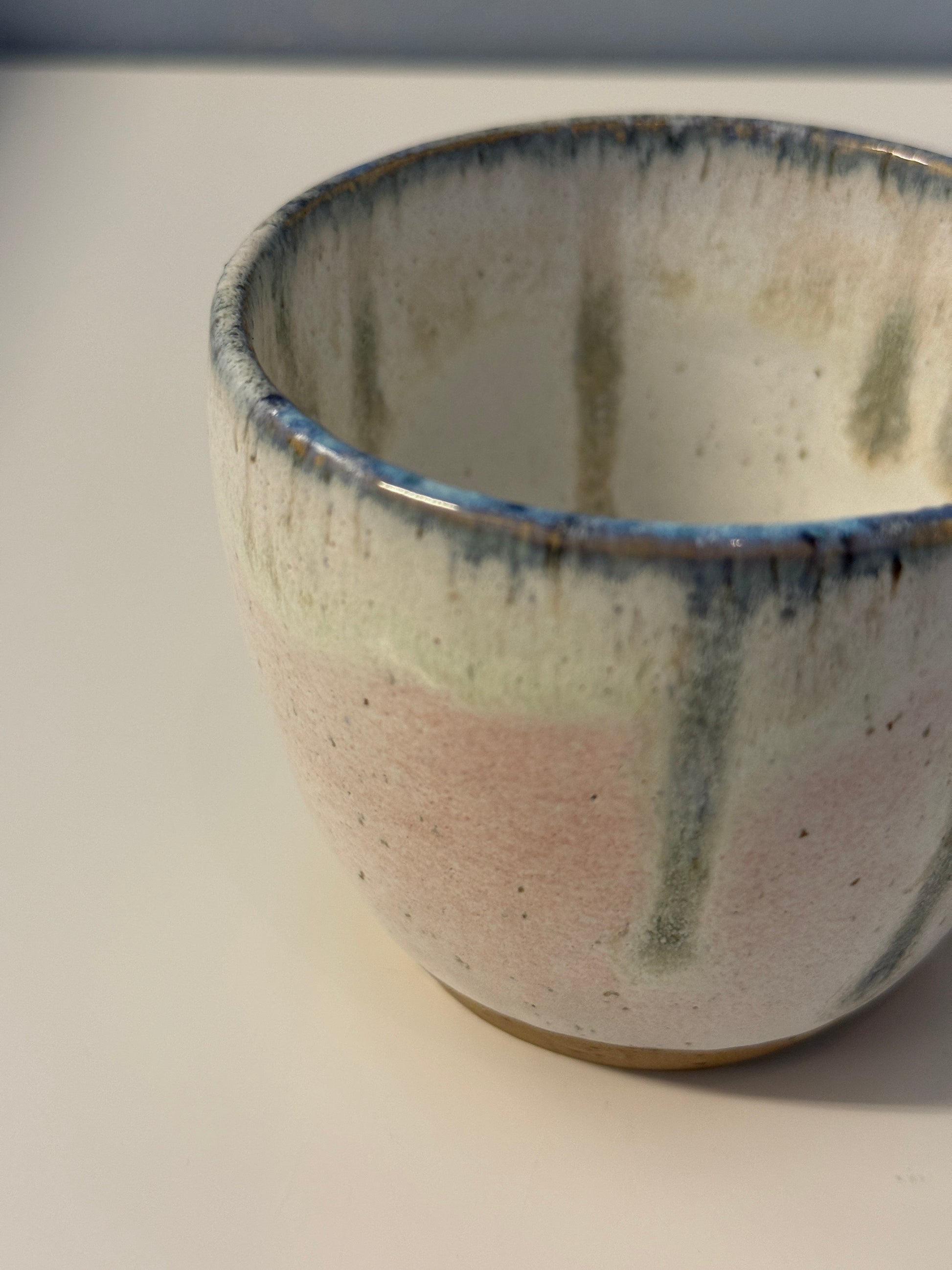 Handgemachte Becher glasiert in weiß mit blauen Tropfen