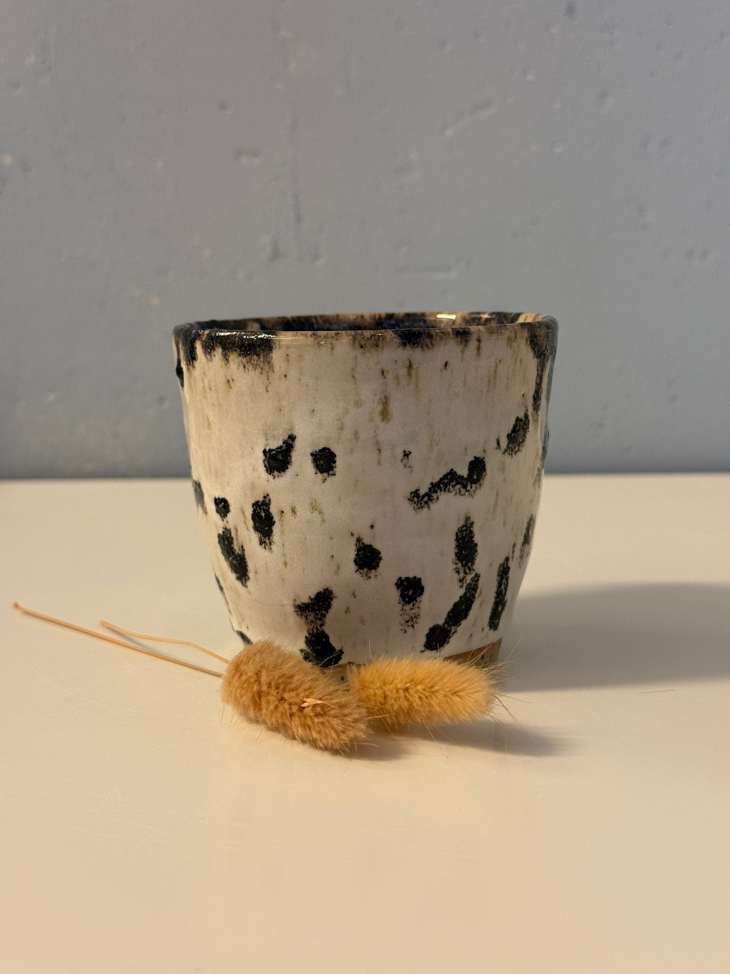 Handgemachter Becher weiß mit schwarzen Punkten