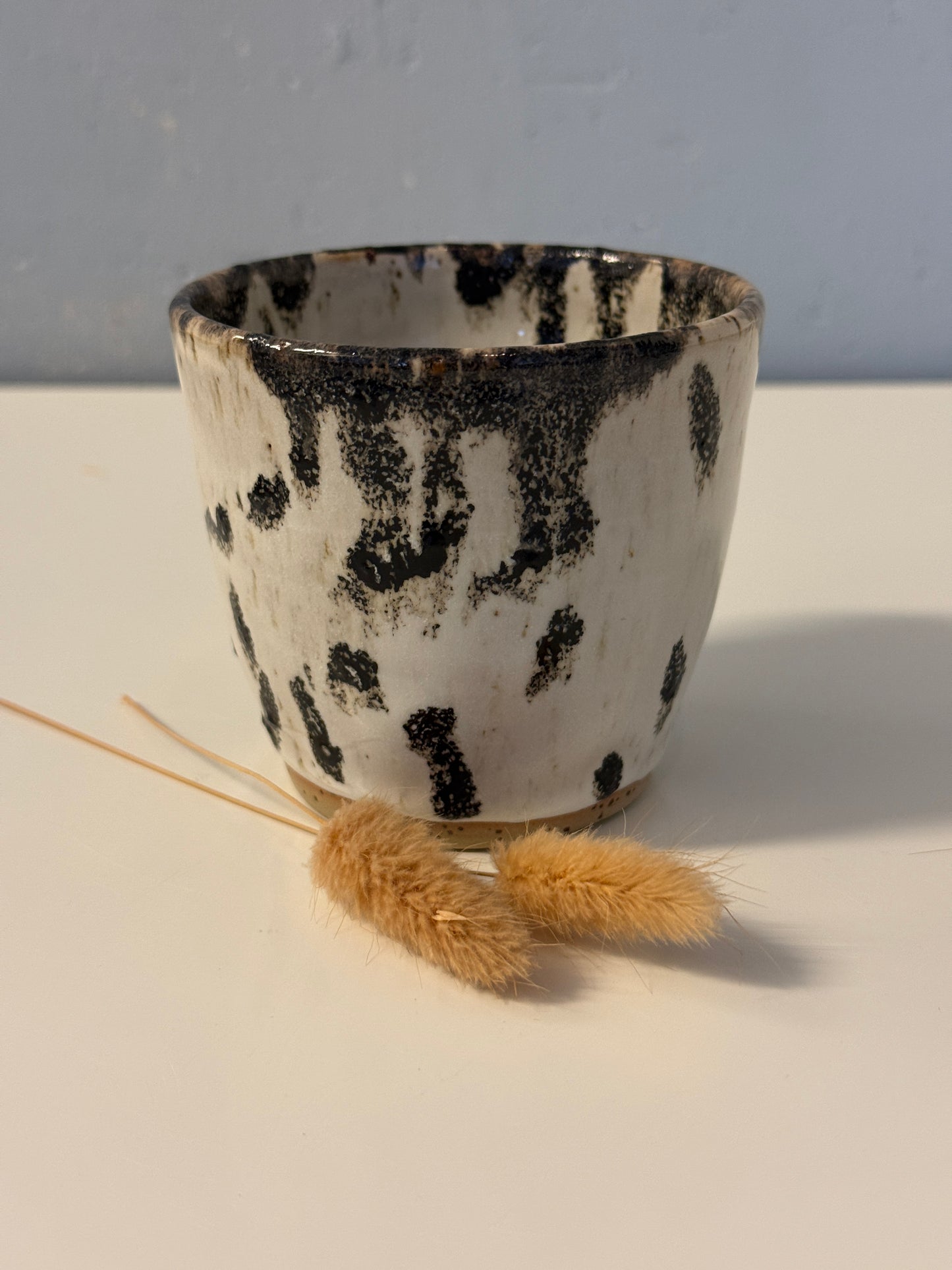 Handgemachter Becher weiß mit schwarzen Punkten