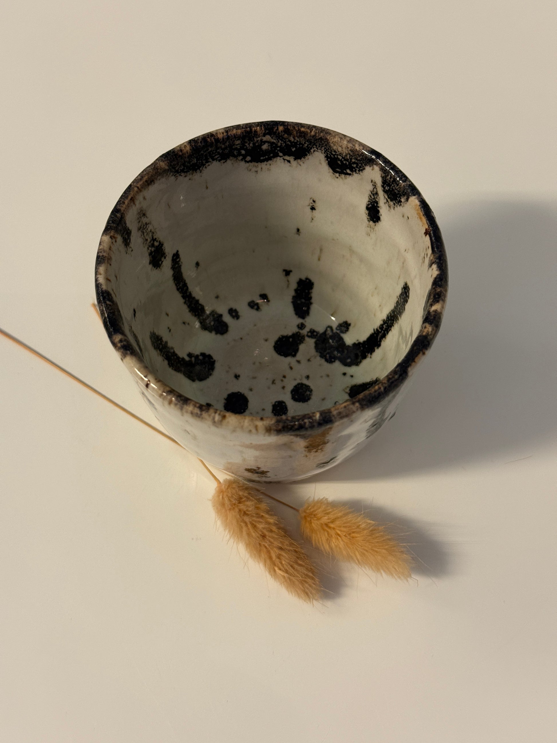 Handgemachter Becher weiß mit schwarzen Punkten